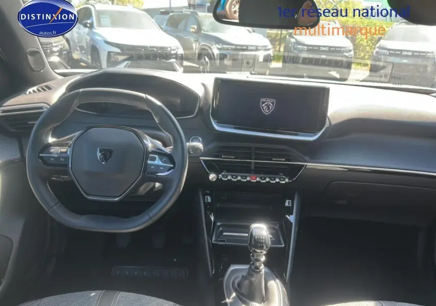 Vue intérieure du tableau de bord et volant de la Peugeot 2008 gris artense avec boîte manuelle et écran tactile central.