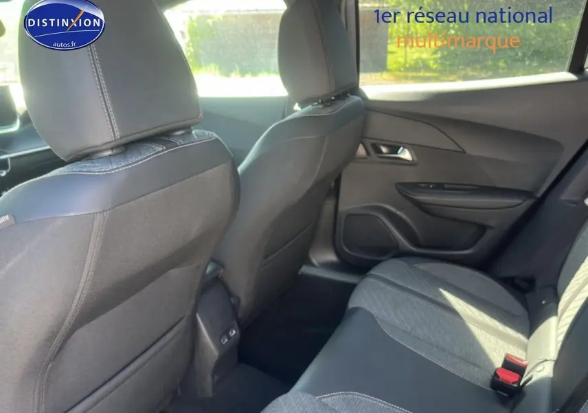 Vue intérieure arrière droite de la Peugeot 2008 1.2 100 Allure 2025, sièges tissu gris et noir avec coutures contrastées.