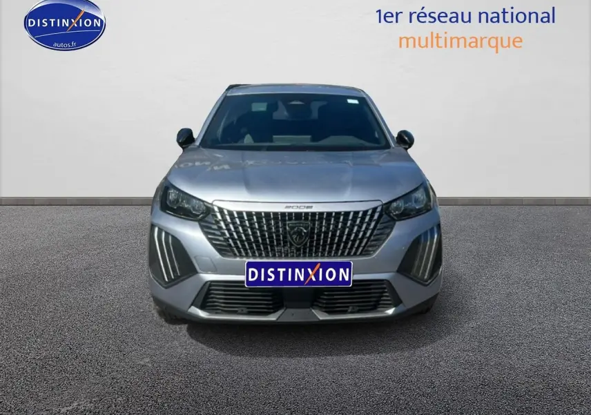 Vue avant d’un Peugeot 2008 gris artense avec calandre distinctive et feux LED verticaux allumés.
