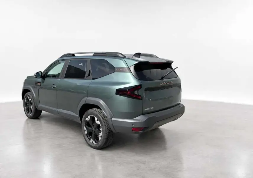Vue 3/4 arrière gauche du Dacia Bigster vert cèdre avec jantes alu noires et barres de toit modulables.
