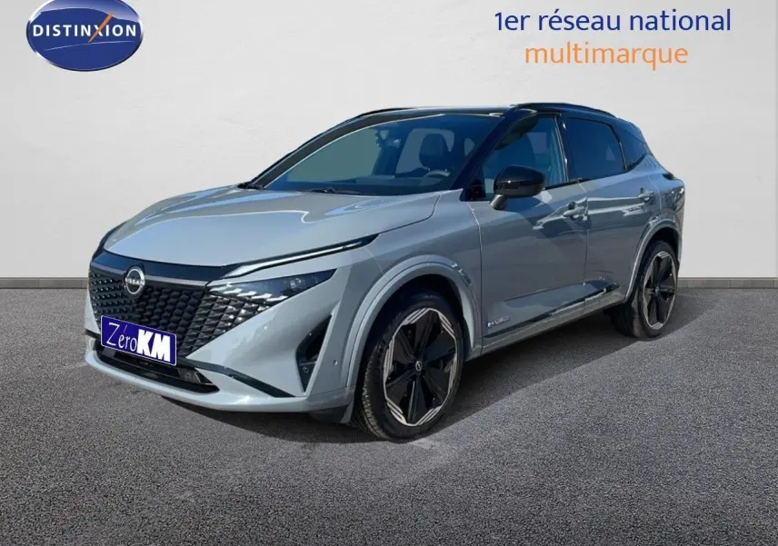 Nissan Qashqai gris céramique métal en 3/4 avant droit, avec jantes noires et toit panoramique visible.