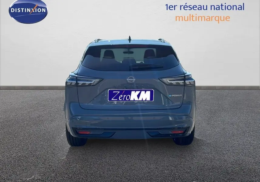 Vue 3/4 arrière droite du Nissan Qashqai gris céramique métallisé avec toit noir panoramique et feux LED allumés.