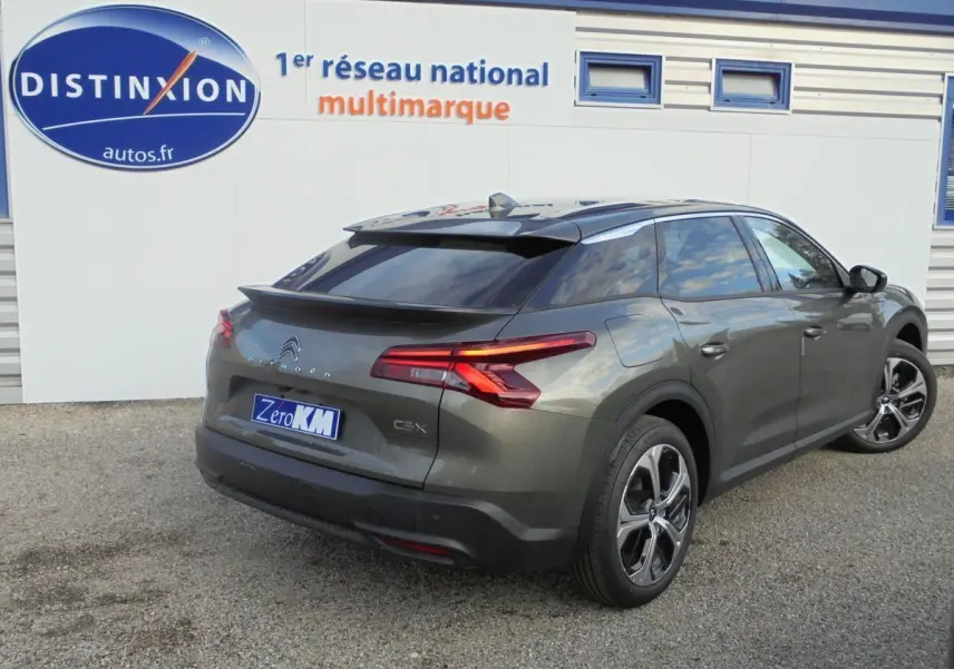 Vue 3/4 arrière droite d'une Citroën C5 X gris platinum 2022 avec feux arrière LED et jantes alliage distinctives.
