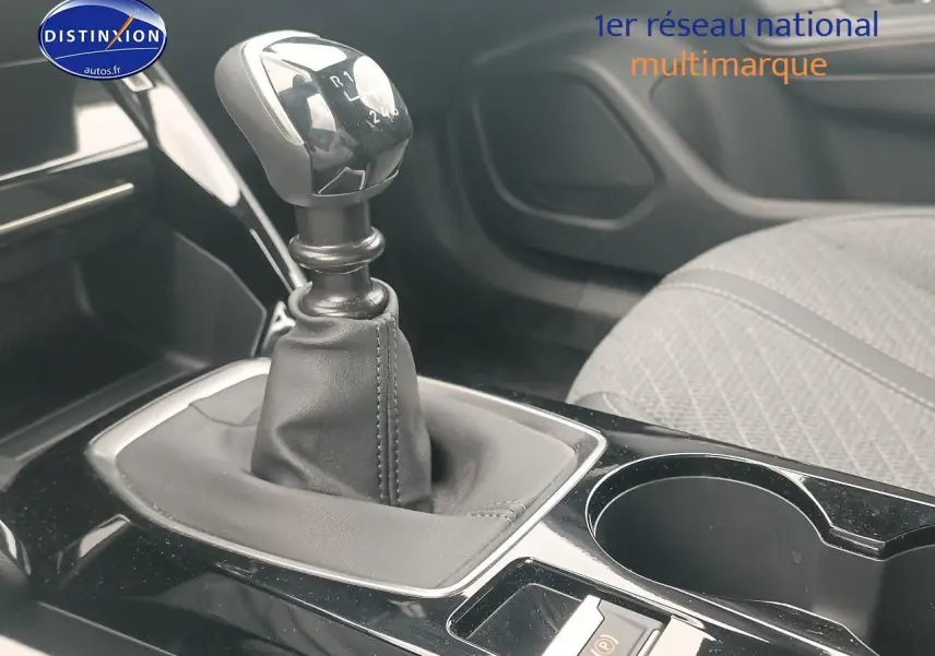 Gros plan sur la boîte manuelle et la console centrale noire avec porte-gobelet du Peugeot 2008 rouge elixir.