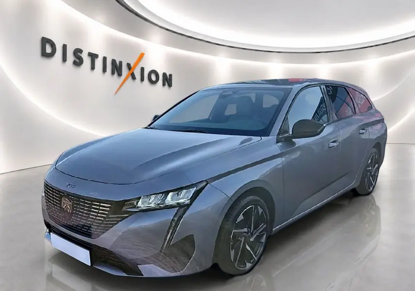 Peugeot 308 SW gris artense vue 3/4 avant droit, avec calandre noire et jantes alliage distinctives.