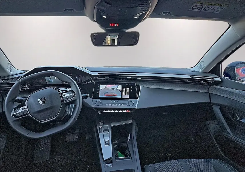 Vue intérieure avant du tableau de bord et volant noir du Peugeot 308 SW 1.5 BlueHDi 130 Gris Artense 2025.
