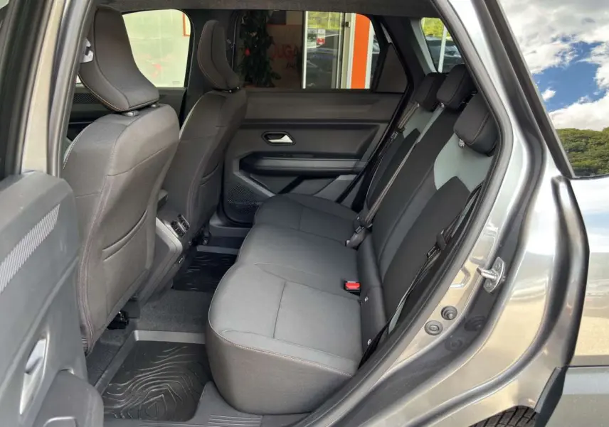 Vue côté droit de l'habitacle arrière du Dacia Bigster gris schiste, montrant la banquette et les sièges en tissu noir.