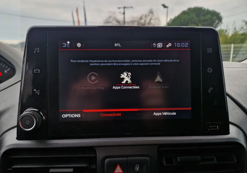 Écran tactile central du Peugeot Partner 2020 affichant les options de connectivité avec logo lion au centre.