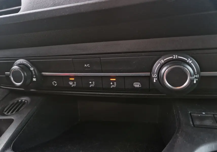 Détail de la console centrale du Peugeot Partner blanc 2020, montrant les commandes de climatisation et ventilation.