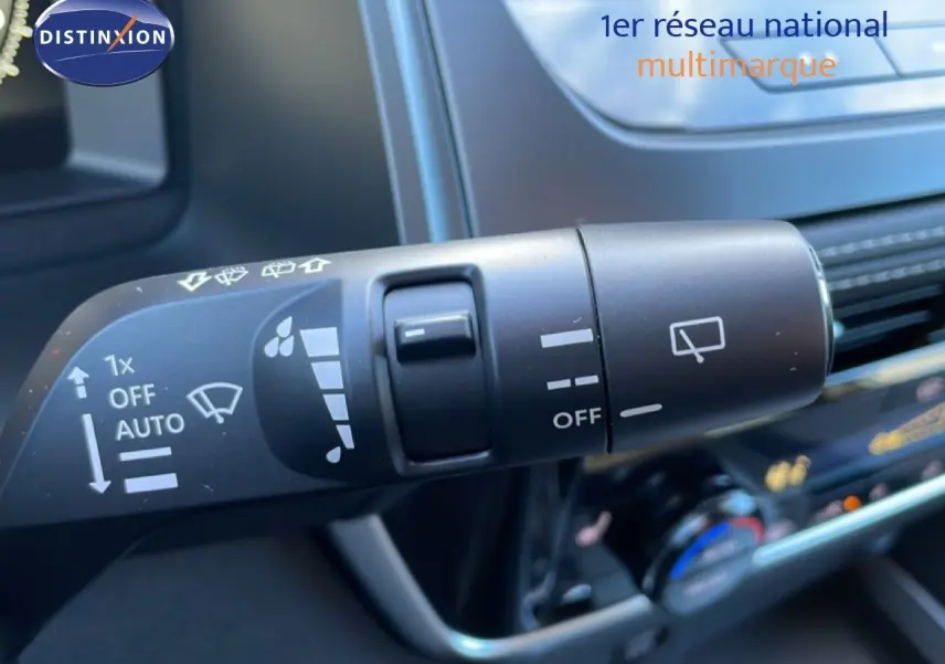 Gros plan sur la commande d’essuie-glace du Nissan Qashqai gris argile, avec tableau de bord en arrière-plan.