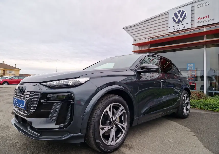Audi Q6 e-tron Performance S-Line gris Manhattan, vue 3/4 avant mettant en valeur sa calandre et ses jantes distinctives.