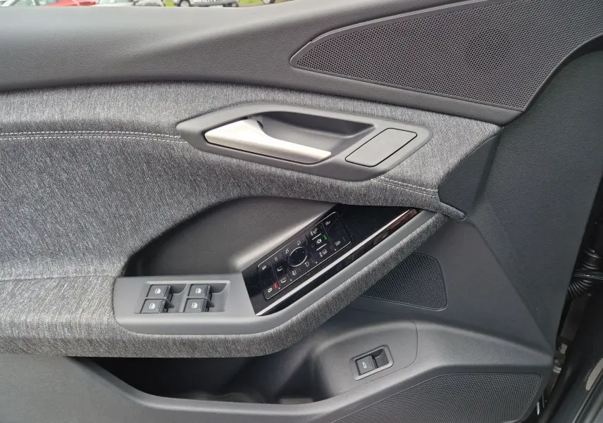 Gros plan sur la porte côté gauche de l'Audi Q6 e-tron Performance S-Line 2025 en gris Manhattan, avec commandes électriques.