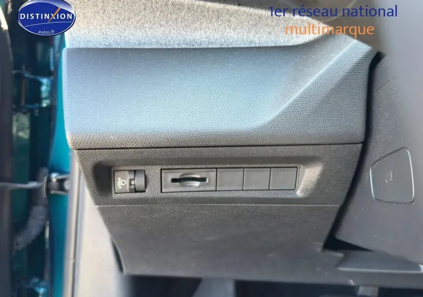 Vue rapprochée de la partie inférieure gauche du tableau de bord d’une Peugeot 408 bleu, avec commandes d’éclairage.