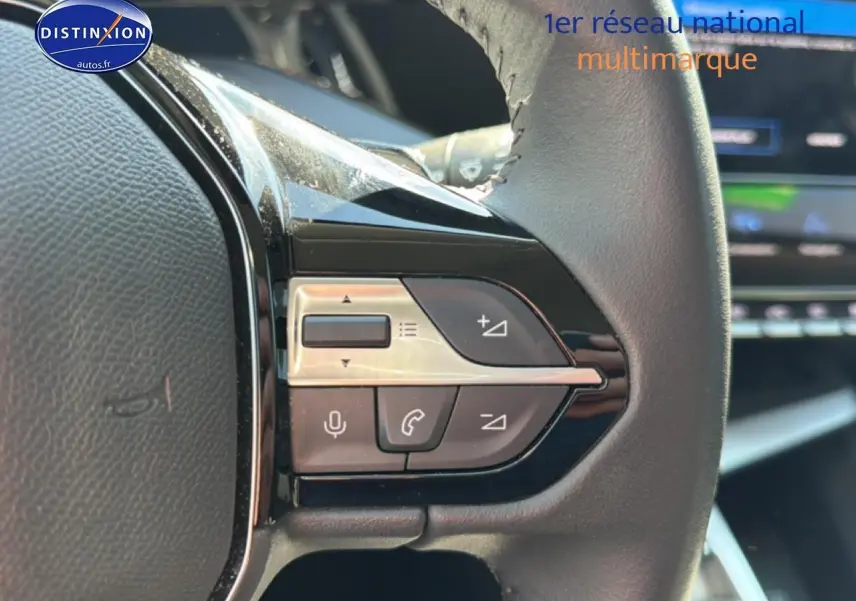 Gros plan sur les commandes vocales et audio au volant cuir noir du Peugeot 408 Hybrid 145 allure bleu 2025.