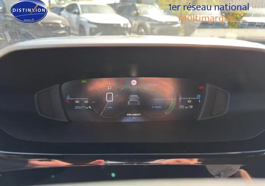 Vue rapprochée du tableau de bord numérique du Peugeot 408 Hybrid 145 allure e-dcs6, affichant la vitesse et l'autonomie.