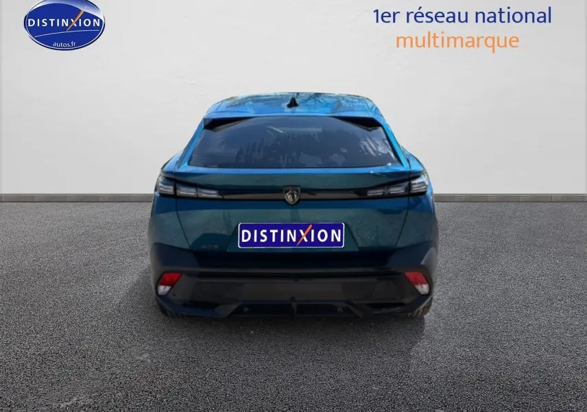 Vue arrière d'une Peugeot 408 Hybrid 145 allure e-dcs6 bleu 2025 avec feux LED et lunette arrière surteintée.
