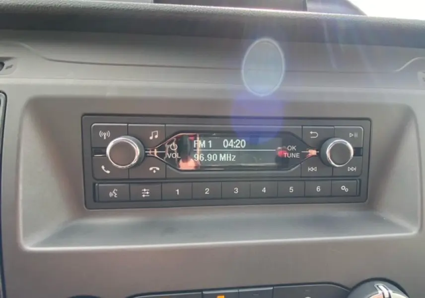 Gros plan sur la radio et les commandes du tableau de bord du Ford Transit Fourgon blanc, version 2023.