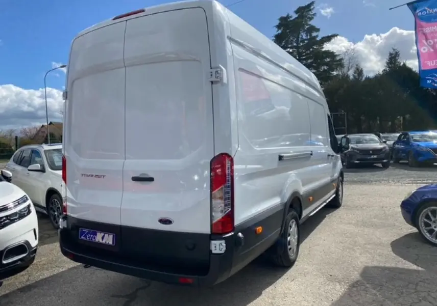 Vue 3/4 arrière droite d’un Ford Transit Fourgon blanc 2023 avec porte latérale coulissante, stationné en extérieur.