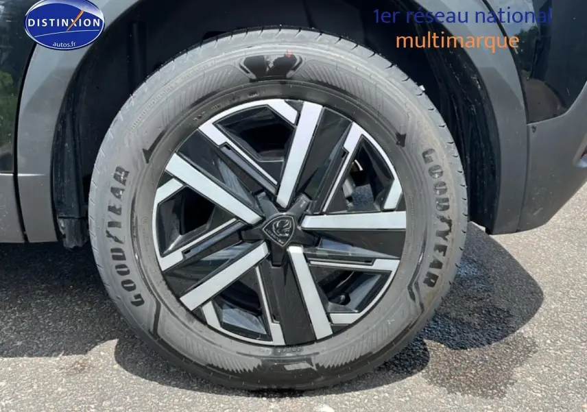Gros plan sur la roue avant droite noire avec jante alliage bicolore du Peugeot 2008 1.2 hybrid 145 style e-dcs6.