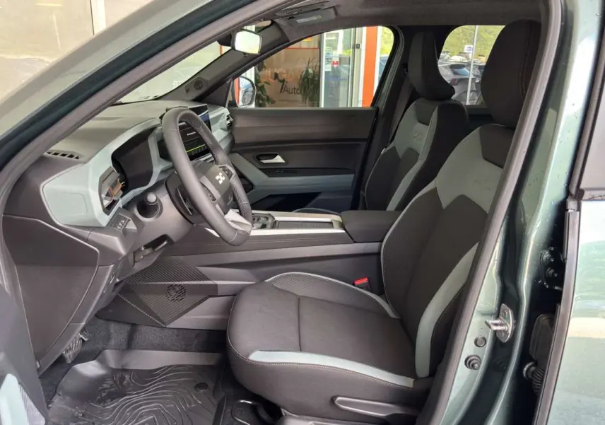 Vue intérieure côté conducteur du Dacia Bigster vert cèdre, avec sièges bi-ton et tableau de bord digital.