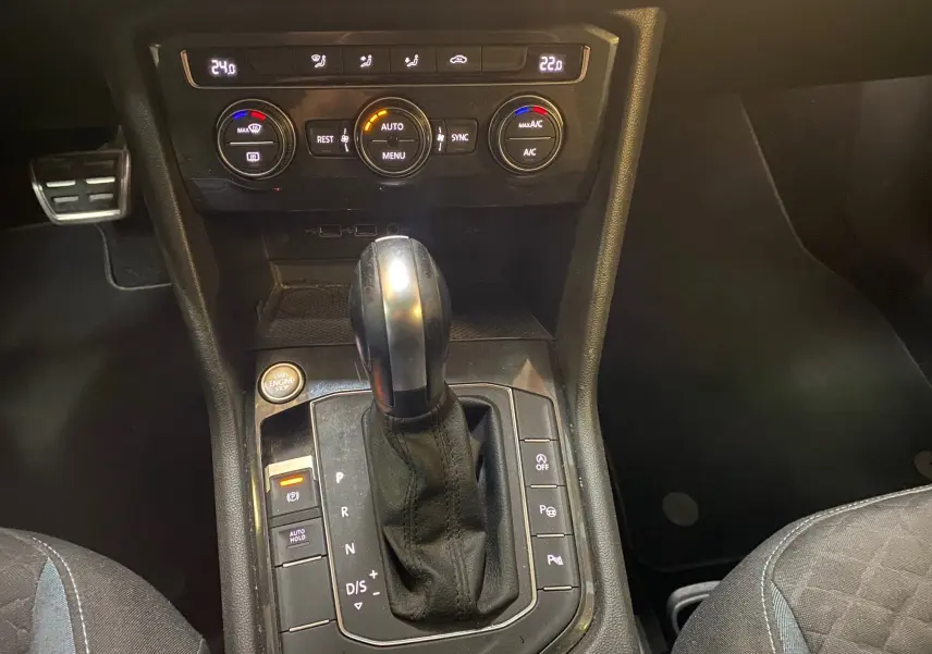 Gros plan sur la console centrale noire du Volkswagen Tiguan 2020 avec levier de vitesse automatique et commandes climatisation.