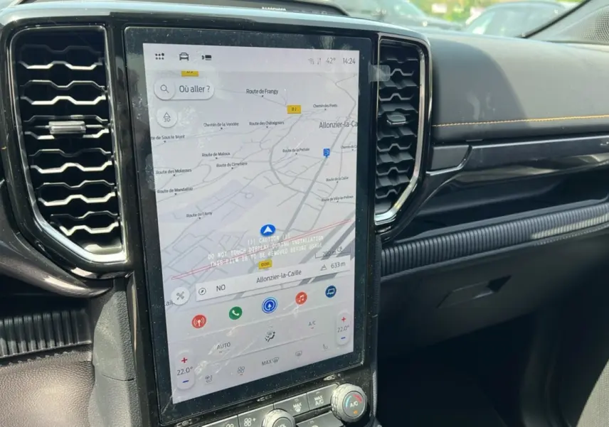 Vue rapprochée de la console centrale du Ford Ranger 2025 noir agate, avec écran tactile affichant la navigation et commandes climatisation.