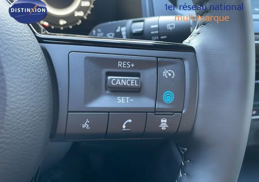 Gros plan sur les commandes de régulateur de vitesse au volant cuir du Nissan Qashqai 2025 gris céramique toit noir.