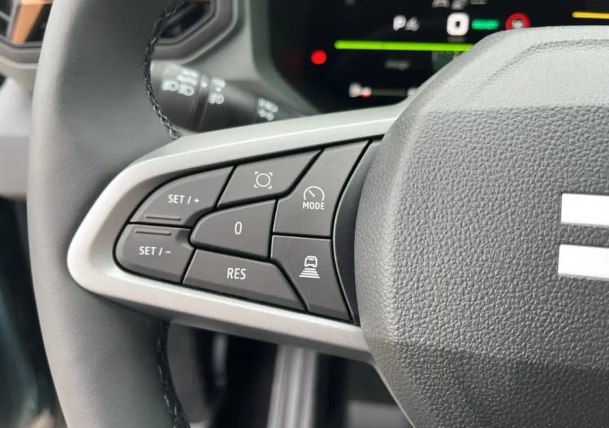 Gros plan sur les commandes du volant cuir du Dacia Bigster Hybrid 155 Extreme Plus, avec boutons multifonctions visibles.