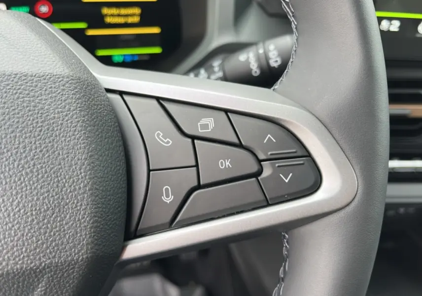 Gros plan sur les commandes au volant cuir du Dacia Bigster Hybrid 155 Extreme Plus, intérieur moderne et fonctionnel.