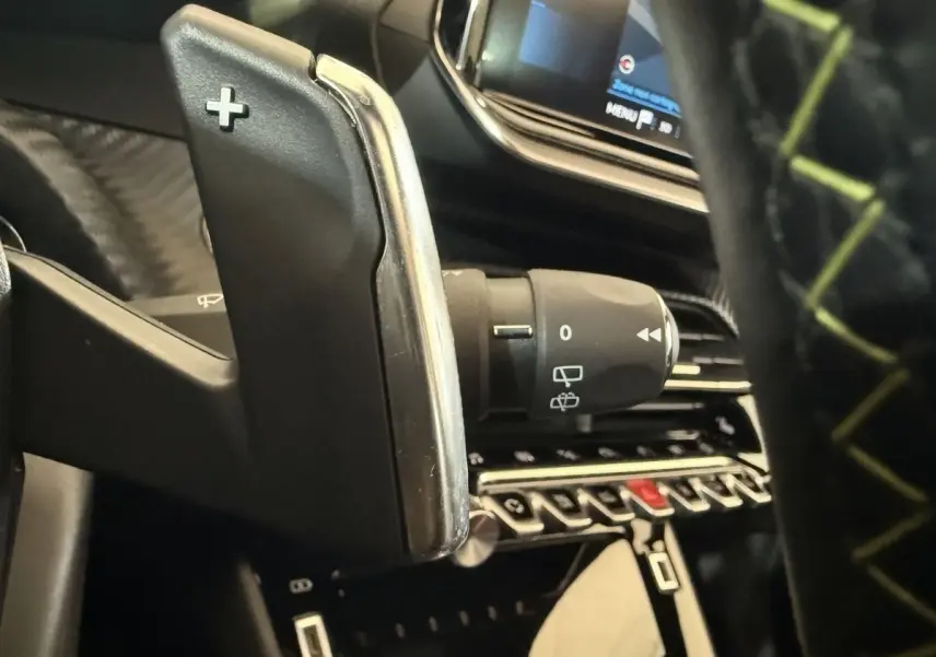 Gros plan sur la palette de changement de vitesse + côté droit du volant d'une Peugeot 2008 GT Pack 2021, intérieur noir.