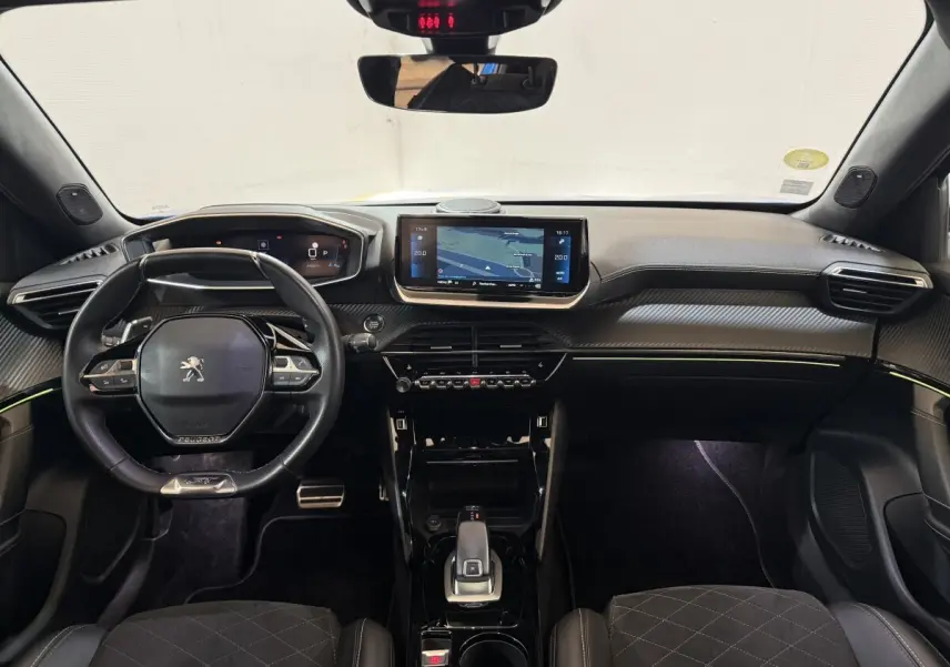 Vue intérieure avant du Peugeot 2008 GT Pack 2021, tableau de bord noir avec écran tactile central et volant compact cuir.