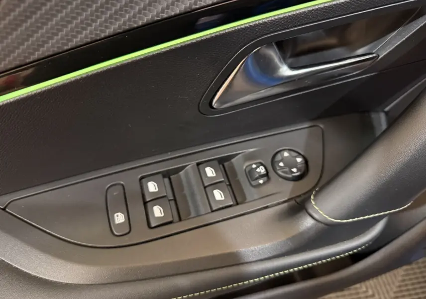 Gros plan sur la porte côté conducteur du Peugeot 2008 bleu, montrant les commandes des vitres et rétroviseurs électriques.