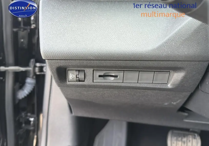 Détail du tableau de bord côté conducteur avec commandes d’éclairage et réglage, intérieur noir.