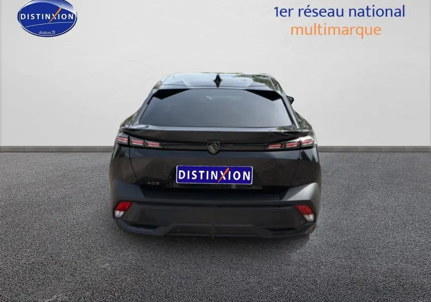 Vue arrière d'une Peugeot 408 bleu foncé 2024 avec feux LED effilés et lunette arrière surteintée.