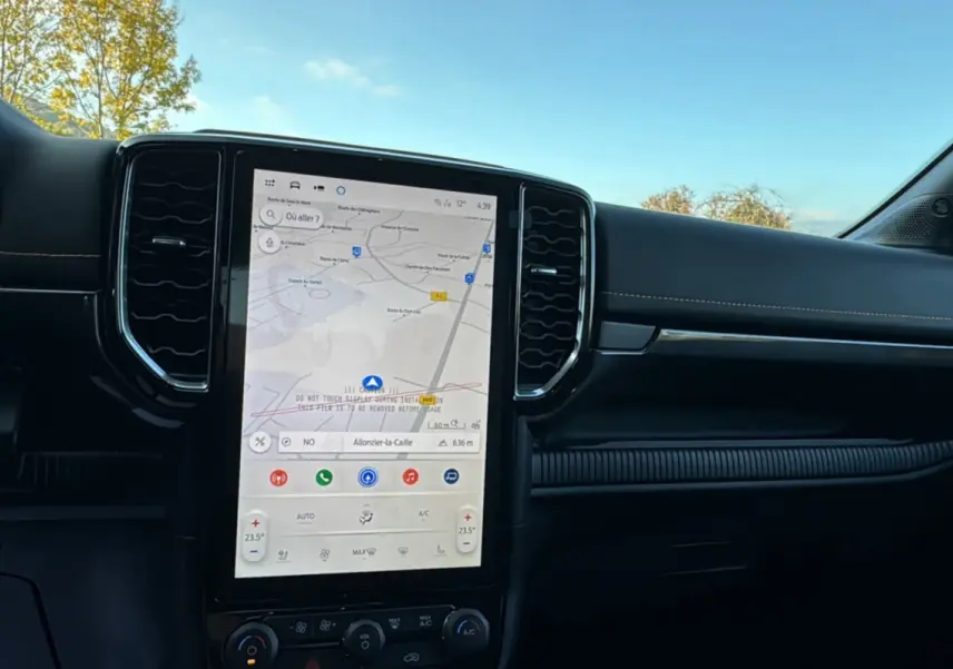 Intérieur du Ford Ranger PHEV 281 Wildtrak gris iconic, vue centrée sur l’écran tactile GPS vertical et tableau de bord.