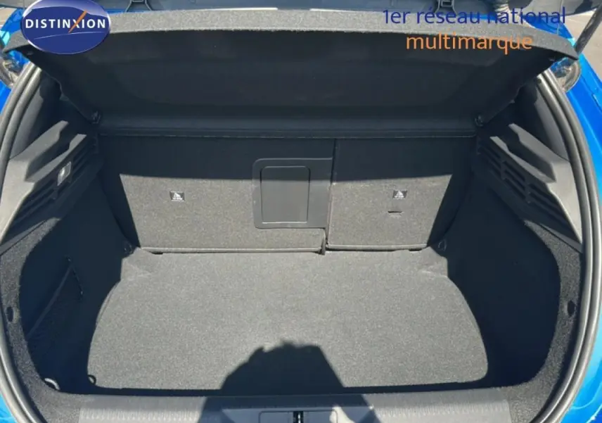 Coffre ouvert vu de face d'une Peugeot 308 bleu clair 2021, montrant un espace de chargement propre et spacieux.