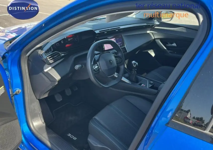 Vue intérieure côté conducteur de la Peugeot 308 bleu clair 2021, avec tableau de bord numérique et écran tactile central.