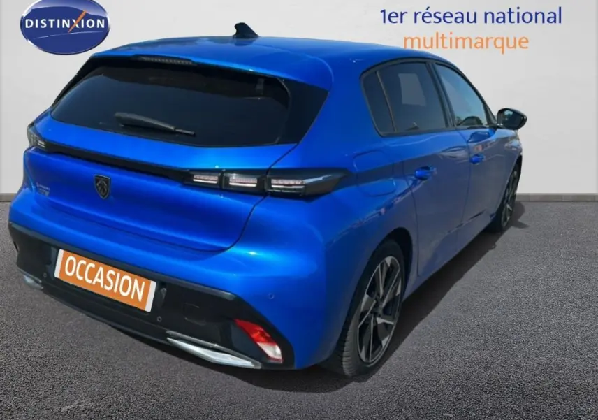 Vue 3/4 arrière droite d'une Peugeot 308 bleu clair avec jantes alliage et feux arrière LED distinctifs.