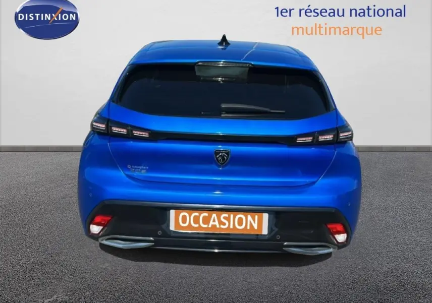 Vue arrière d'une Peugeot 308 bleu clair avec feux LED et double sortie d'échappement intégrée.