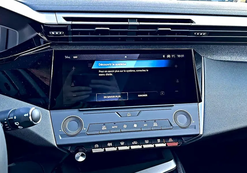 Vue rapprochée de la console centrale noire du Peugeot 308 SW 2025 avec écran tactile et commandes climatisation.