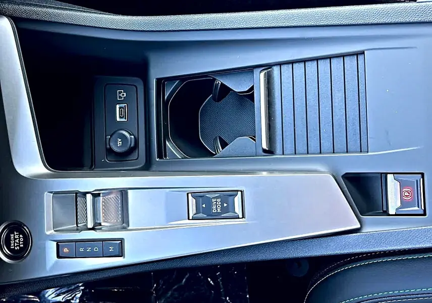 Vue plongeante sur la console centrale grise du Peugeot 308 SW noire, montrant levier de vitesse et rangements.