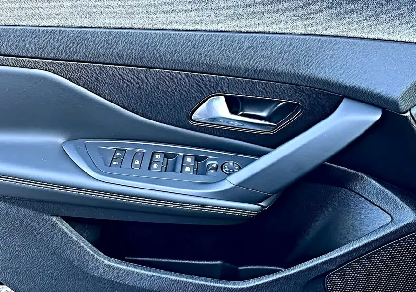 Vue rapprochée de la porte avant gauche noire de la Peugeot 308 SW avec commandes de vitres et rétroviseurs.