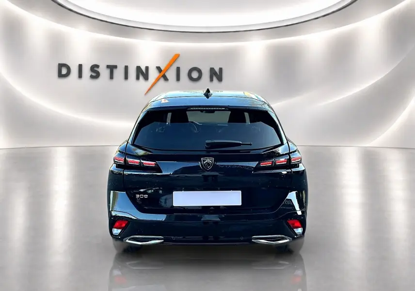 Vue arrière d'une Peugeot 308 SW noire 2025 dans un showroom avec éclairage moderne et logo Distinxion en arrière-plan.