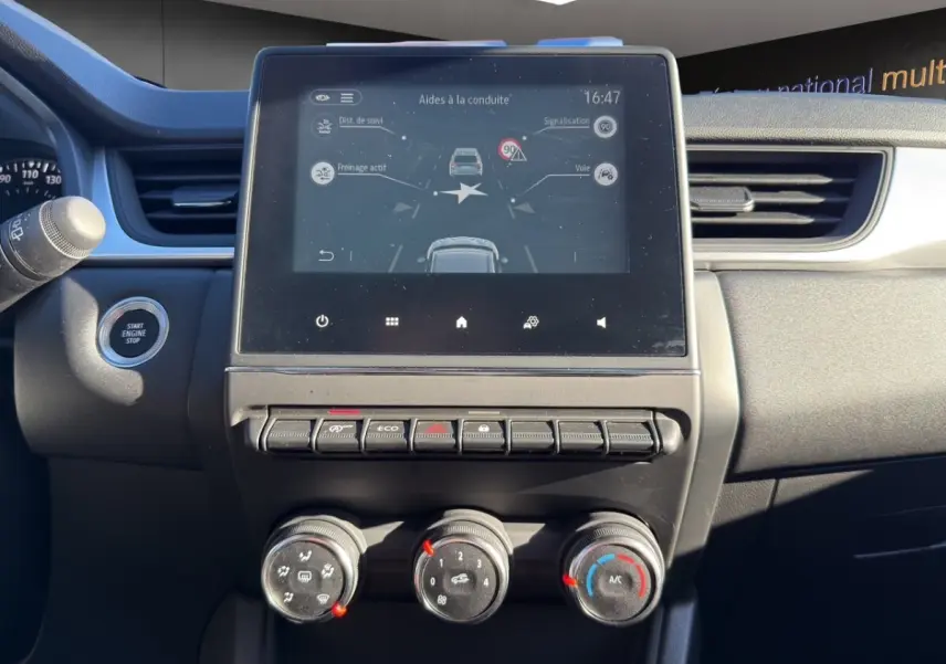 Vue rapprochée du tableau de bord du Renault Captur gris foncé 2024, avec écran tactile central affichant les aides à la conduite.