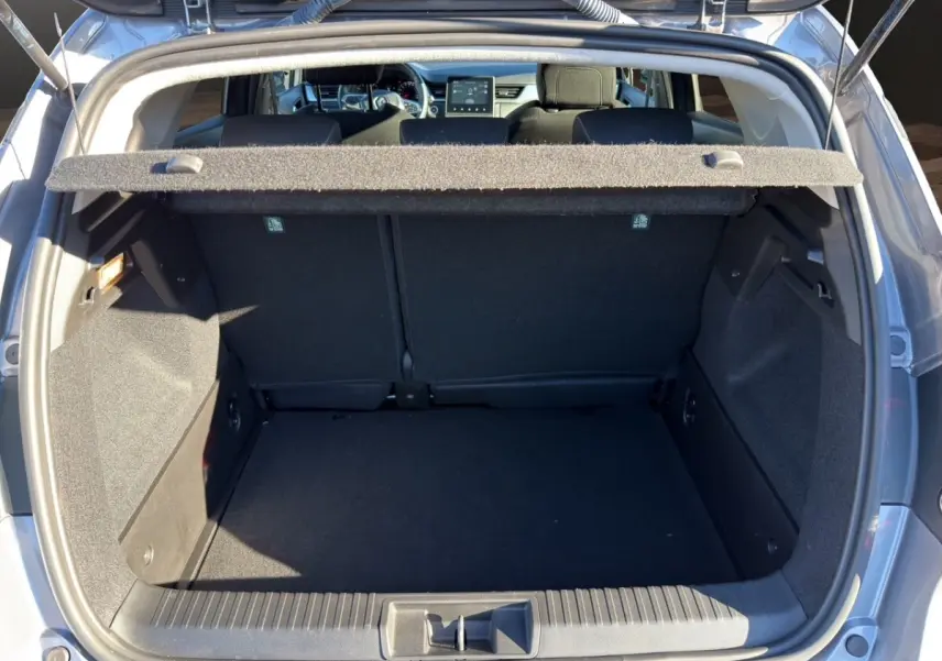 Coffre ouvert vu de l'arrière du Renault Captur gris foncé 2024, montrant l'espace de chargement vide et la tablette cache-bagages.