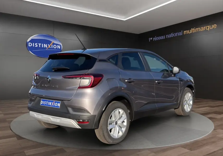 Vue 3/4 arrière droite du Renault Captur gris foncé 2024 avec feux LED et jantes alliage visibles en showroom.