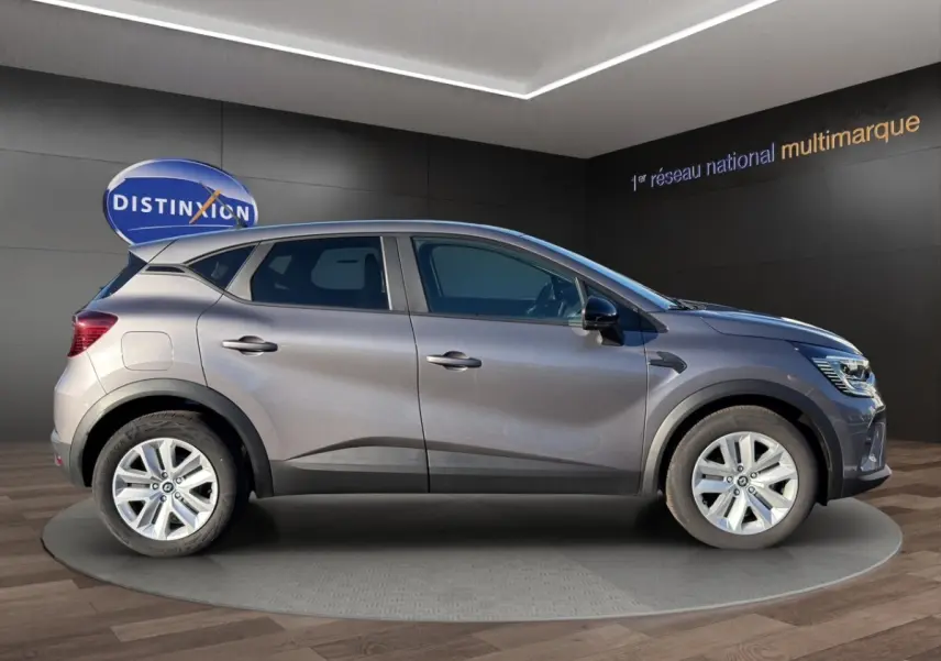 Profil côté gauche du Renault Captur gris foncé 2024 sur plateau tournant en showroom avec jantes alliage.
