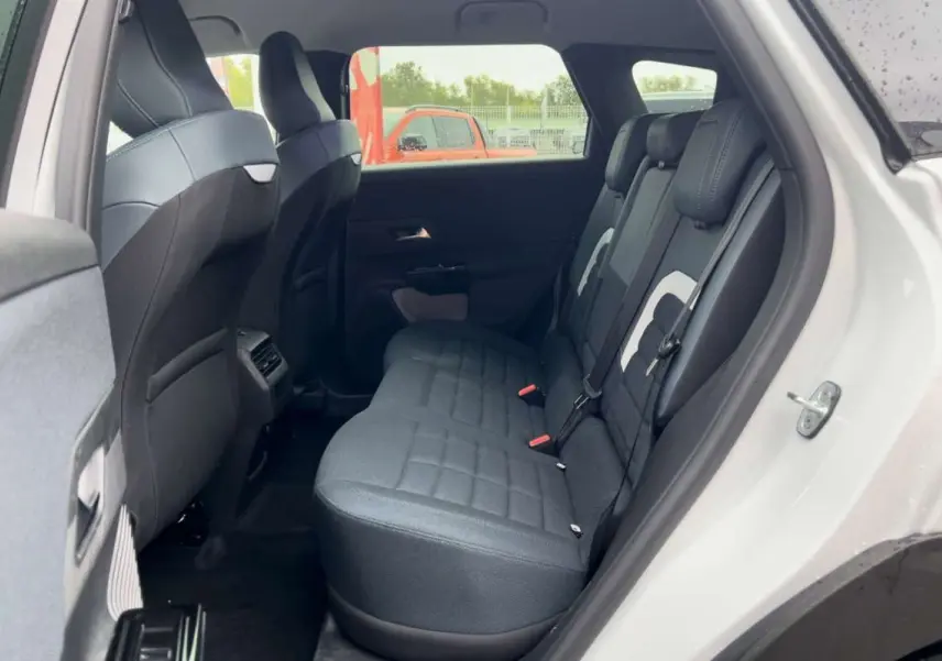 Vue intérieure arrière côté gauche du Citroën C5 Aircross blanc avec sièges noirs et détails gris clairs.