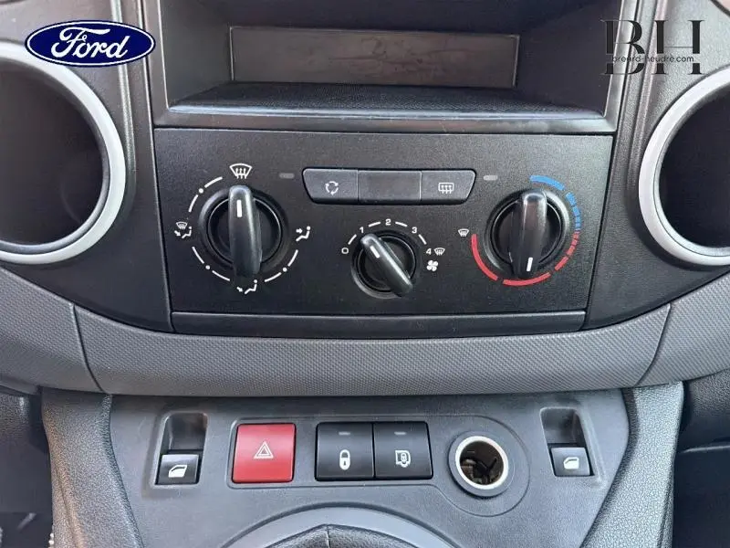 Tableau de bord central en gros plan avec commandes de climatisation et boutons, intérieur noir du Citroën Berlingo blanc.