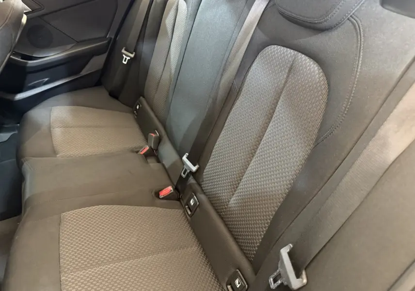 Vue rapprochée de la banquette arrière noire de la BMW Série 1 116i Business Design avec ceintures et fixations Isofix visibles.